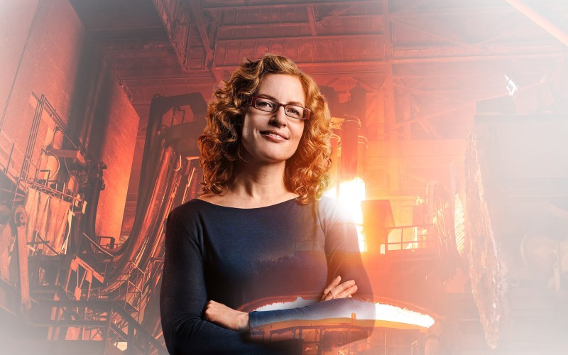 Materials scientist Andrea with foundry and glowing copper in the background