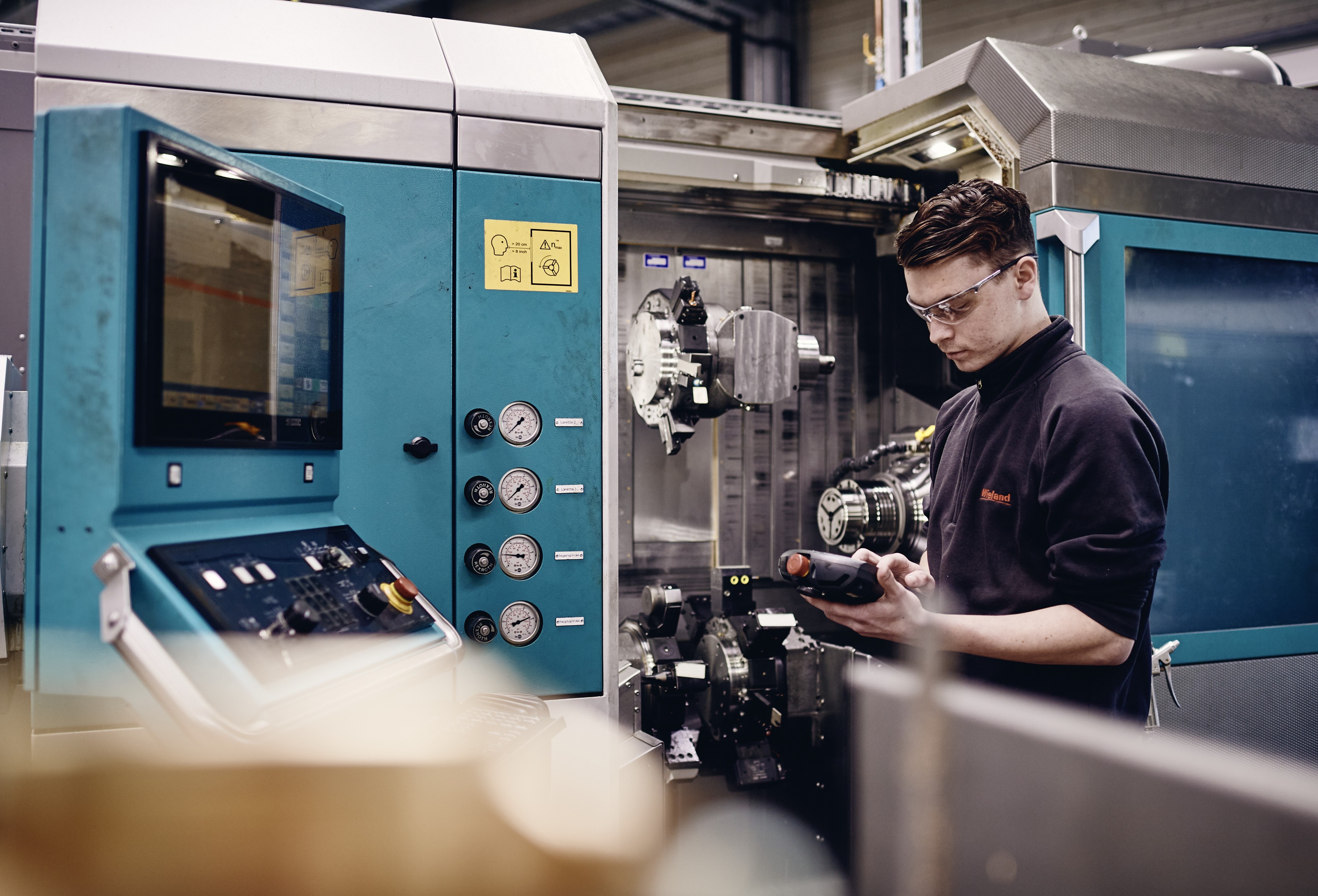 Young male trainee working on a machine