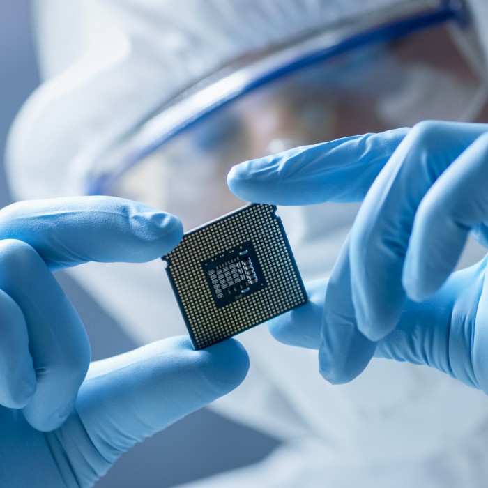 Laboratory technician wearing safety clothes is holding a chip