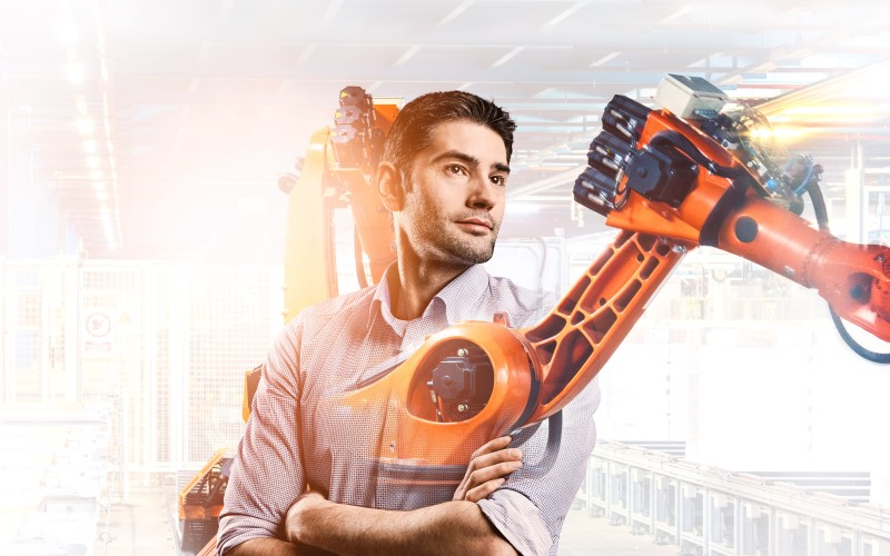 Design engineer Fabian with production robot in the background