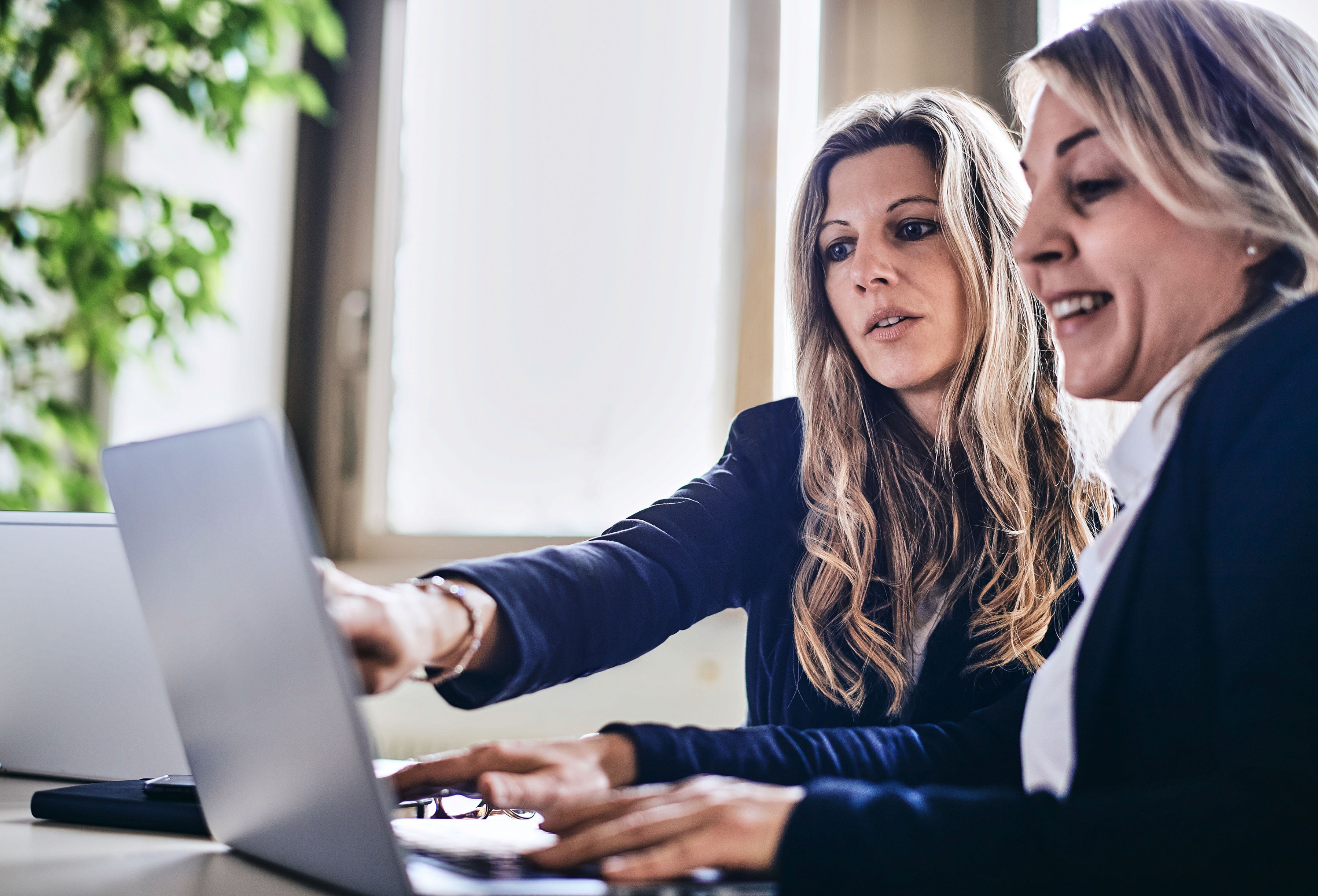 Two female employees sitting in front of a computer