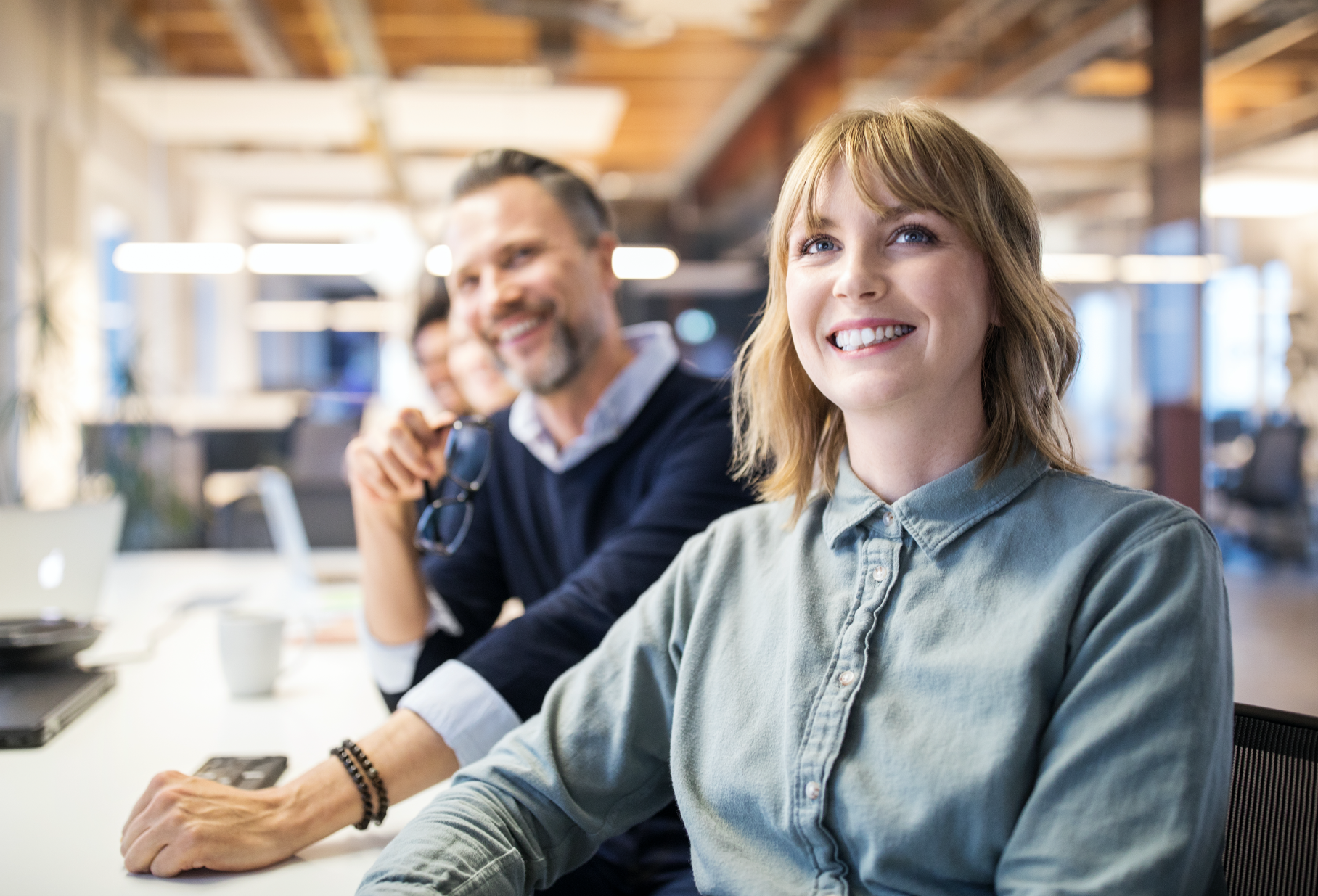 Young and smiling female employee with her co-workers