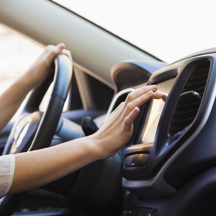 Woman touching display in car