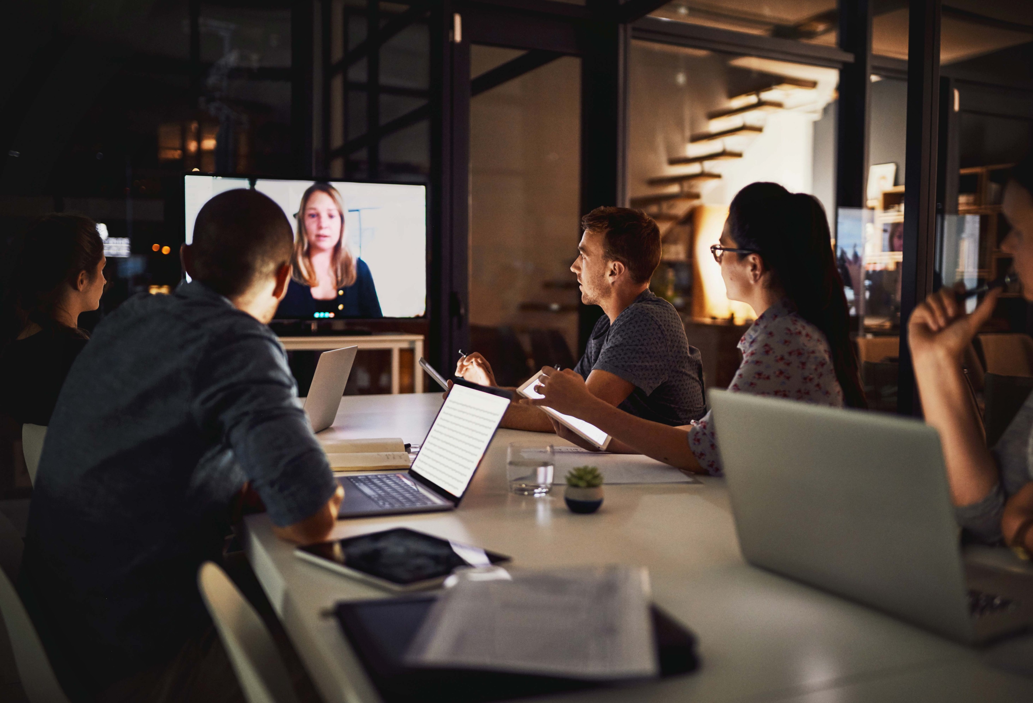 Team of employees in a video conference at night