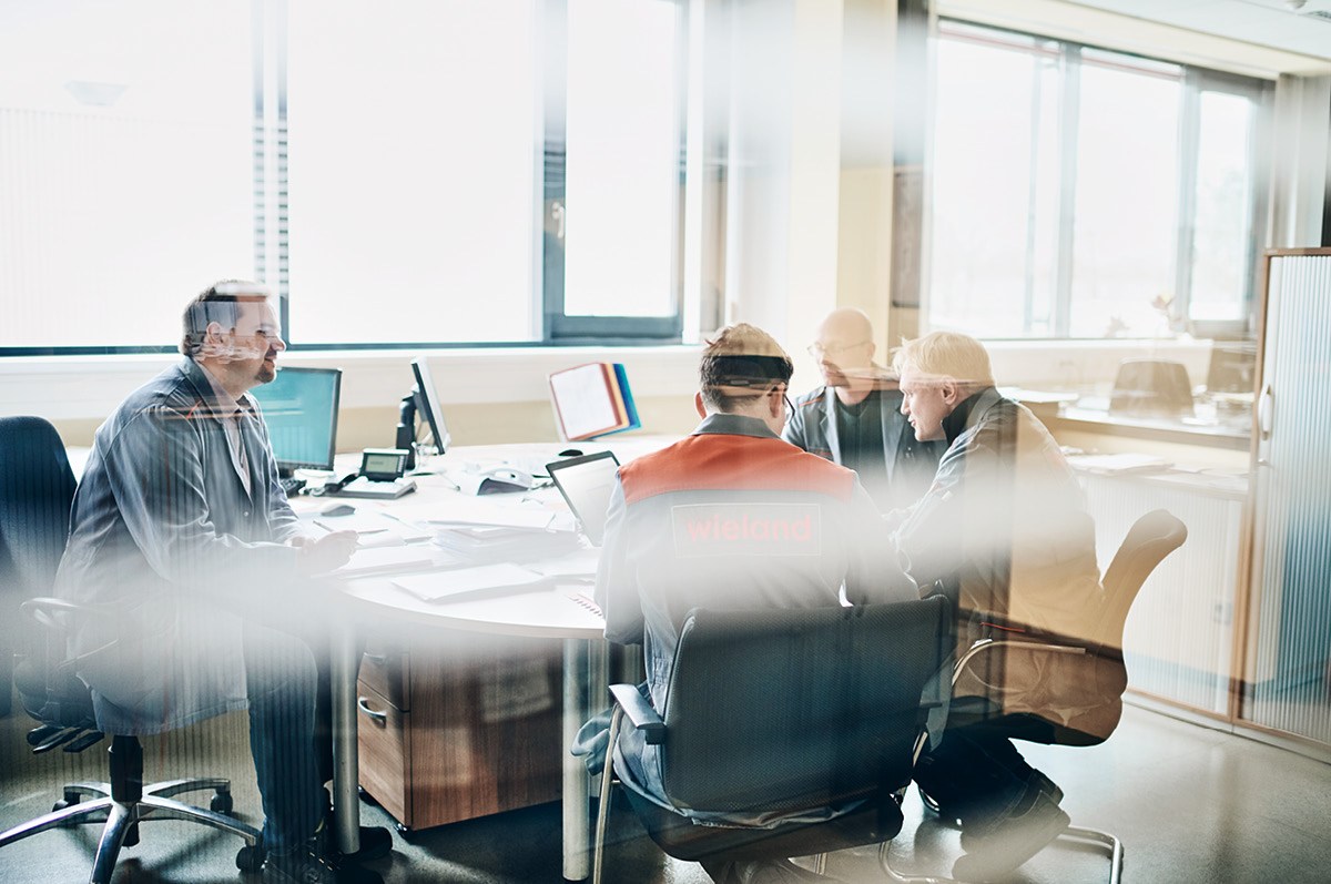 A group of engineers sitting together an meeting