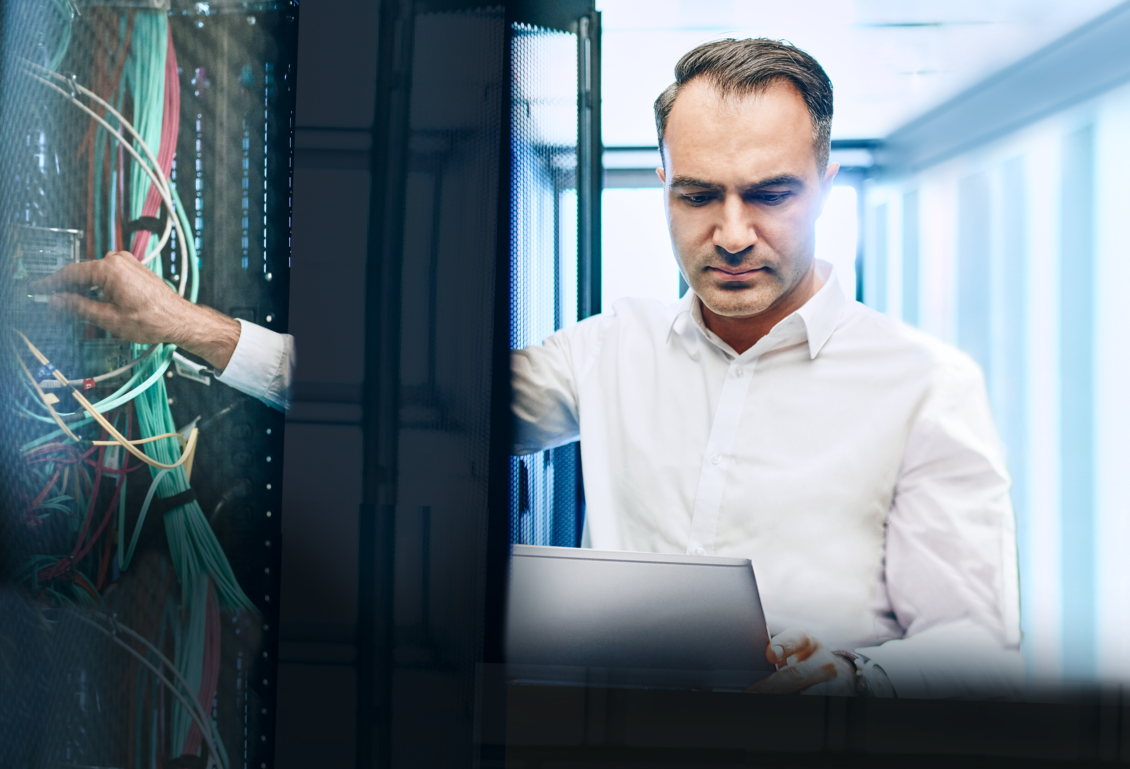 IT expert standing in front o f a server rack holding a tablet