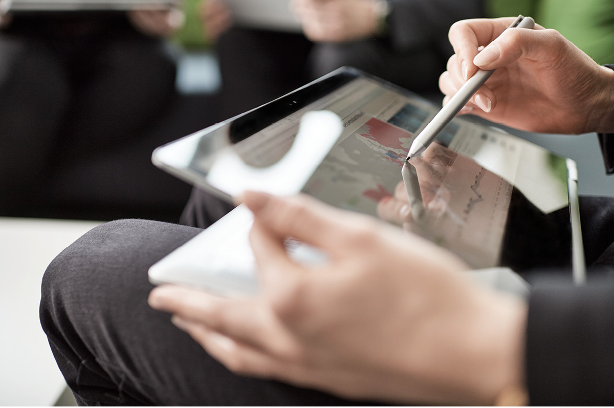 Two female hands holding a tablet and a touchpen