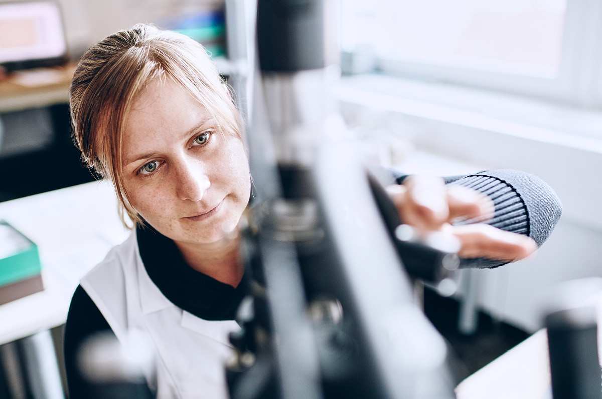 Female material scientist adjusting a electron microscope