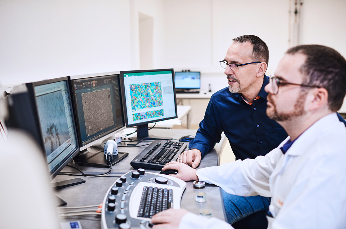 Two material scientits sitting together in front of a computer