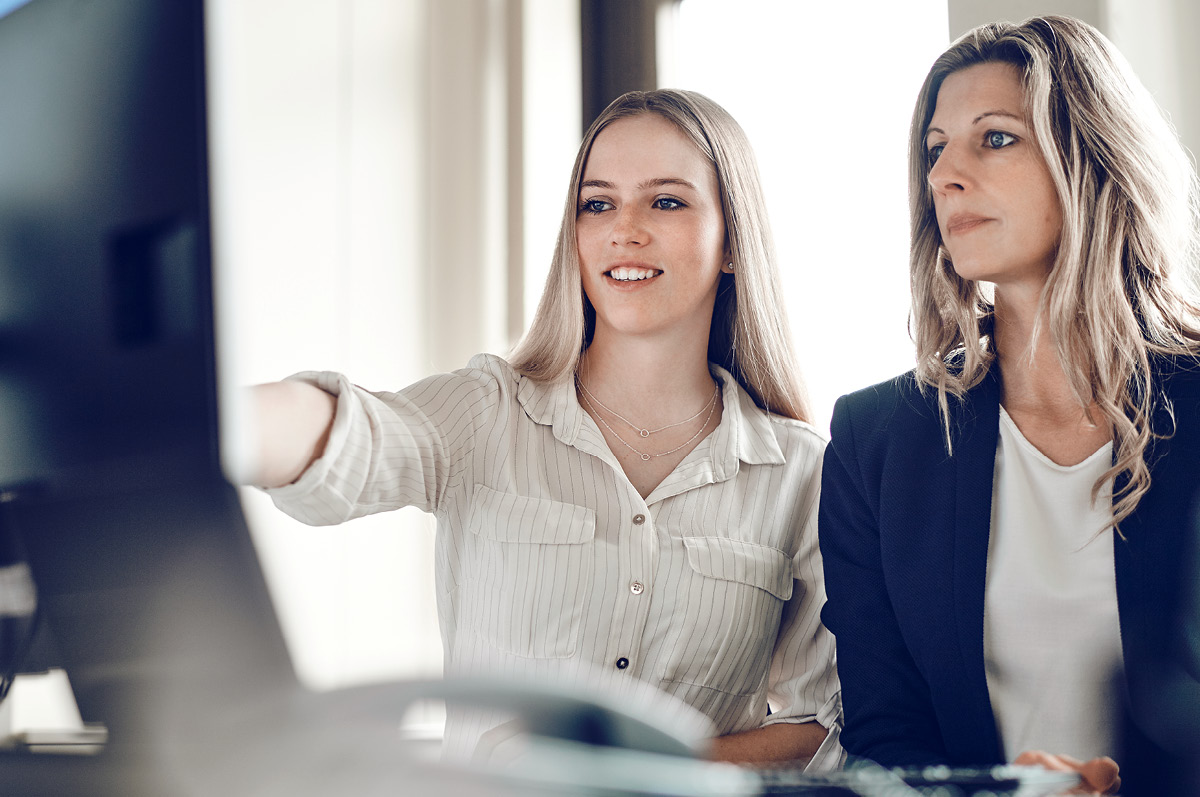 Two female employees sitting in front of a computer