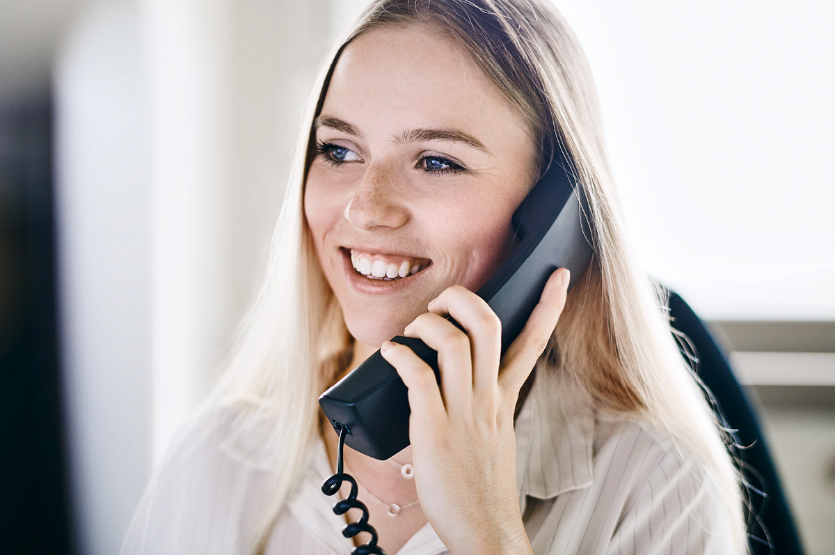 Young smiling female employee talking on the phone