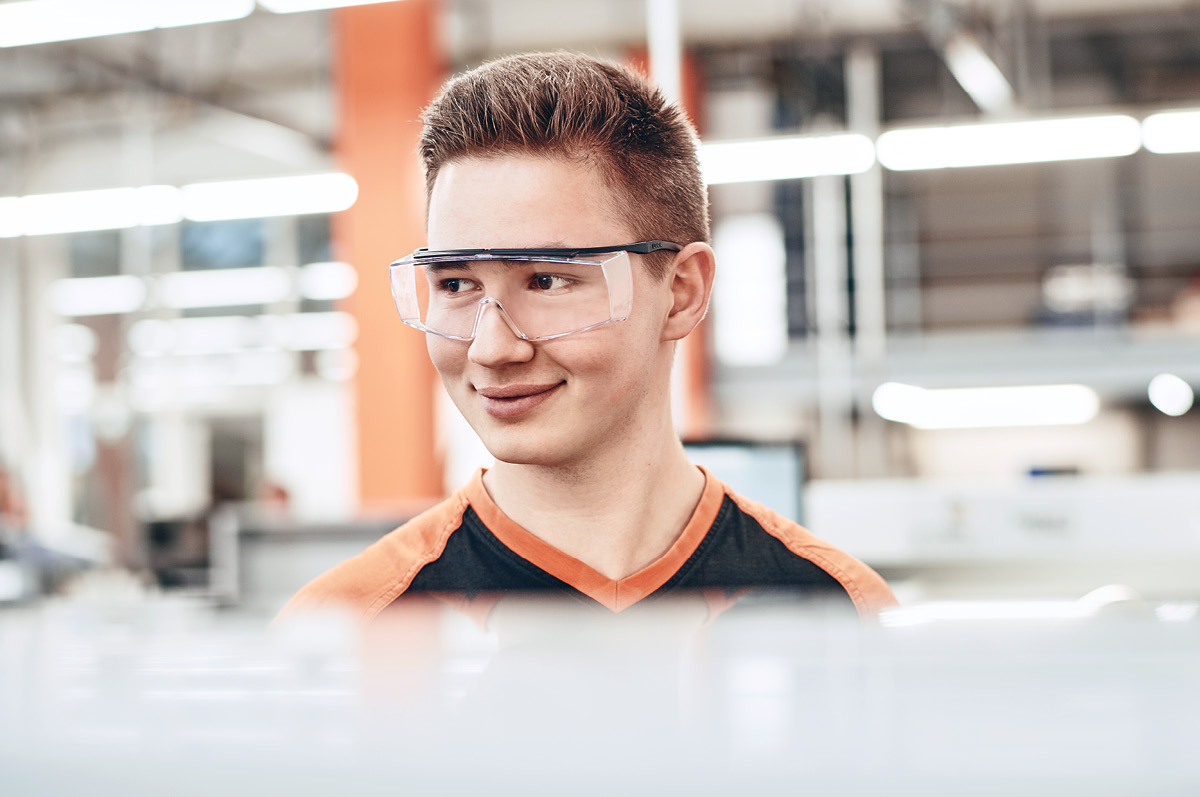 Young male trainee wearing protection glasses smiling
