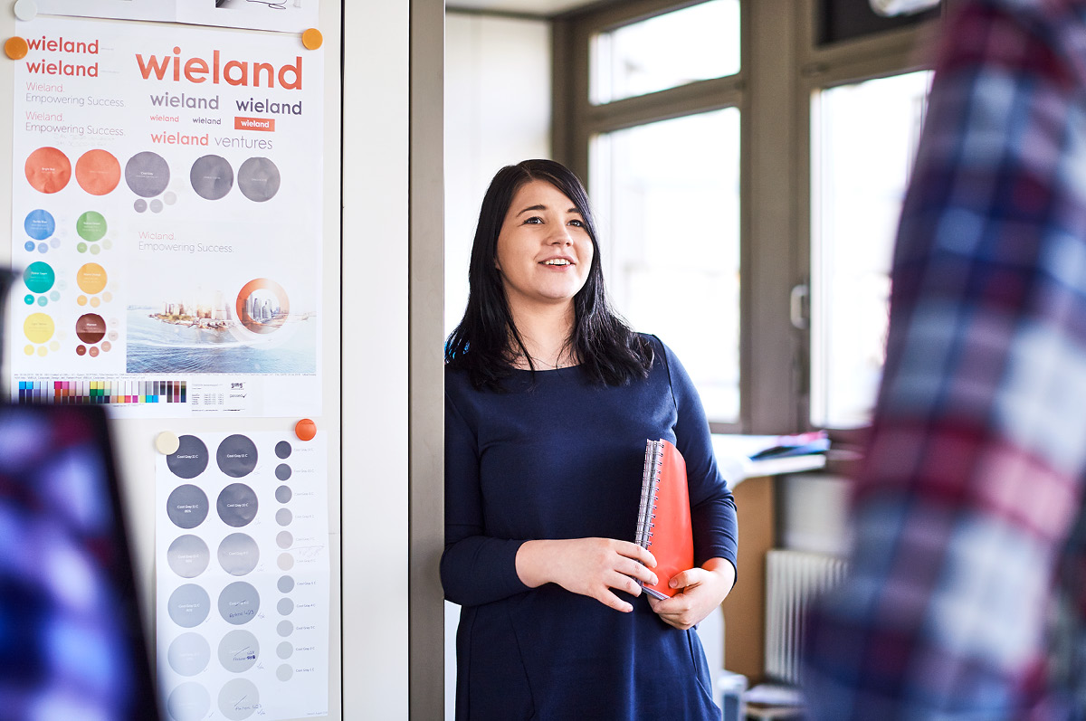 Young and smiling female employee holding a folder